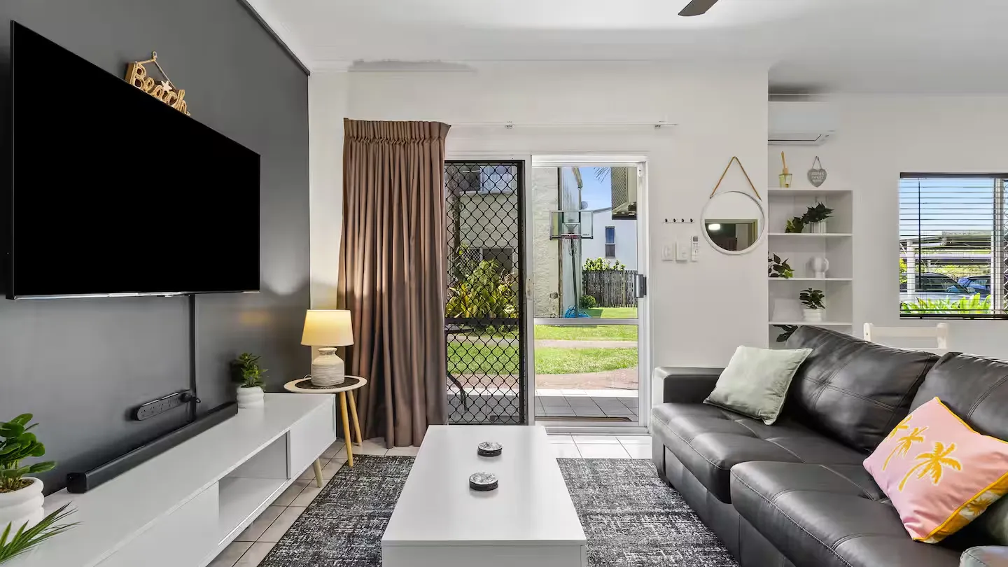 Living room with smart TV, lounge and doors to the patio
