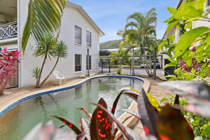 Pool surrounded by palms and tropical plants at the Edge Hill complex