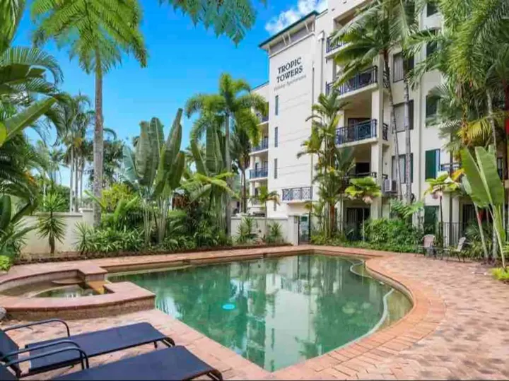 Resort pool and spa surrounded by palms at Tropic Towers