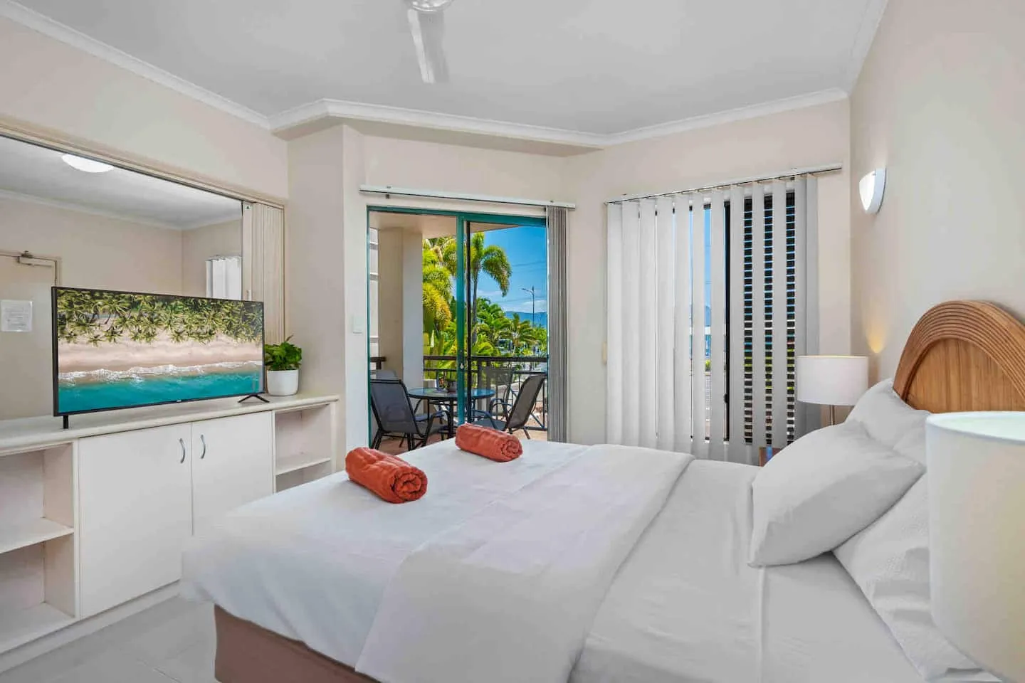 Queen bedroom with TV and balcony doors