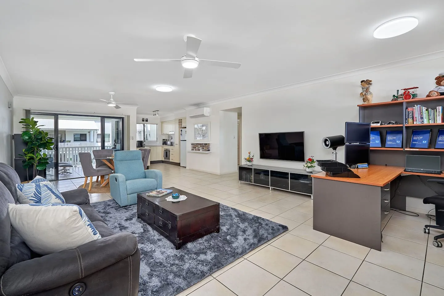 Open-plan living room with lounge, TV and home office desk